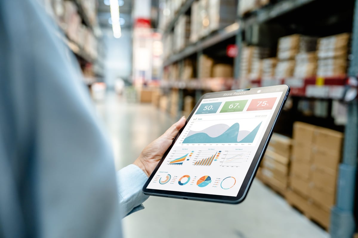 Warehouse employee monitoring an analytics dashboard on a tablet