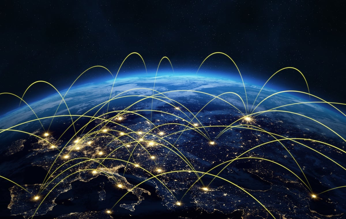 Earth at night with glowing network lines showing global communication and data transfer